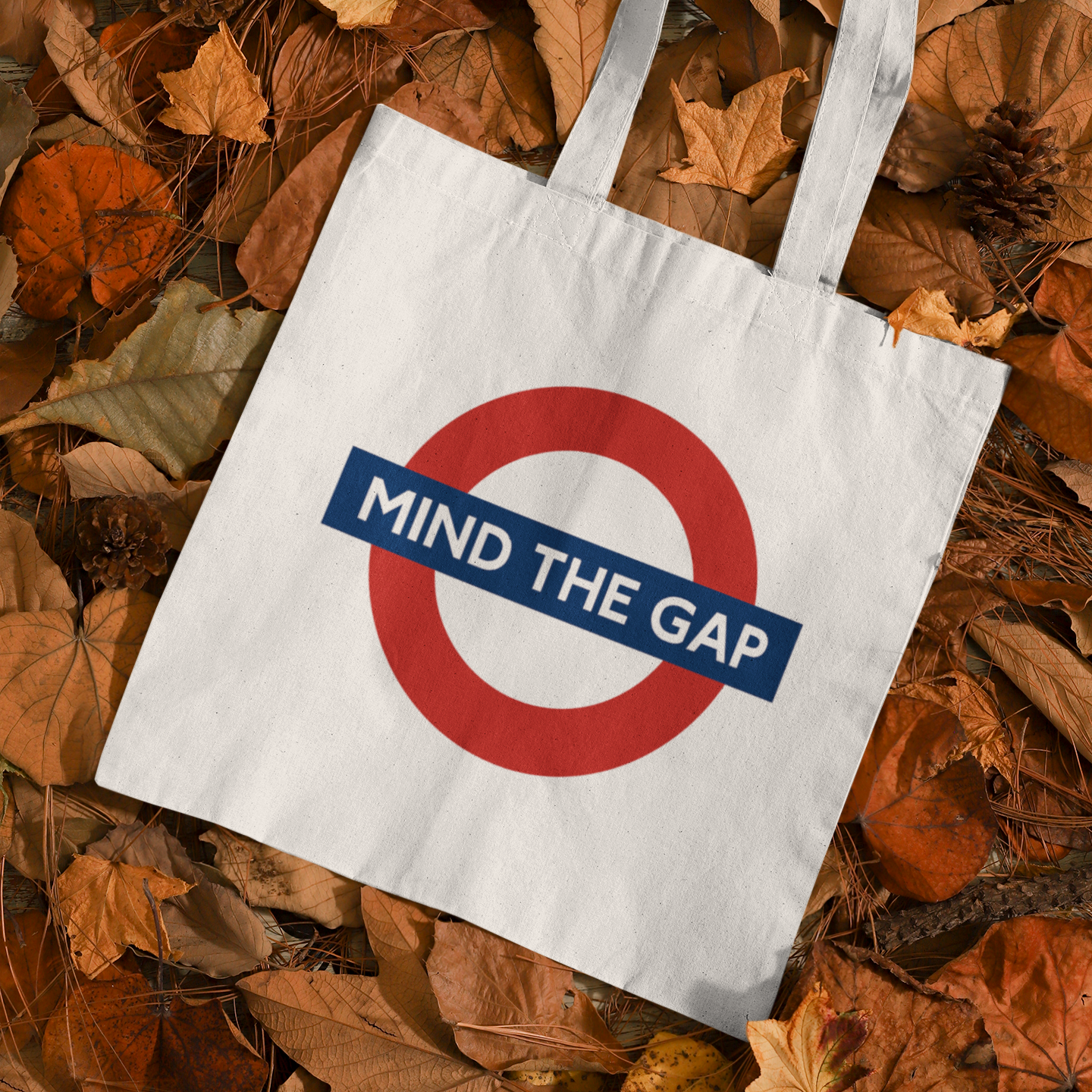 Mind The Gap streetwear city tote bag displayed on autumn leaves β stylish eco tote inspired by London Underground design