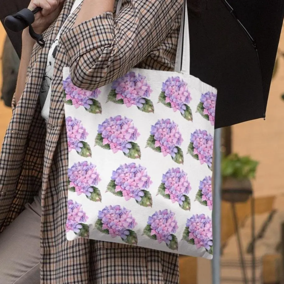 Woman carrying Hydrangea Patterned Floral Design Tote Bag with pink hydrangea print while holding an umbrella outdoors