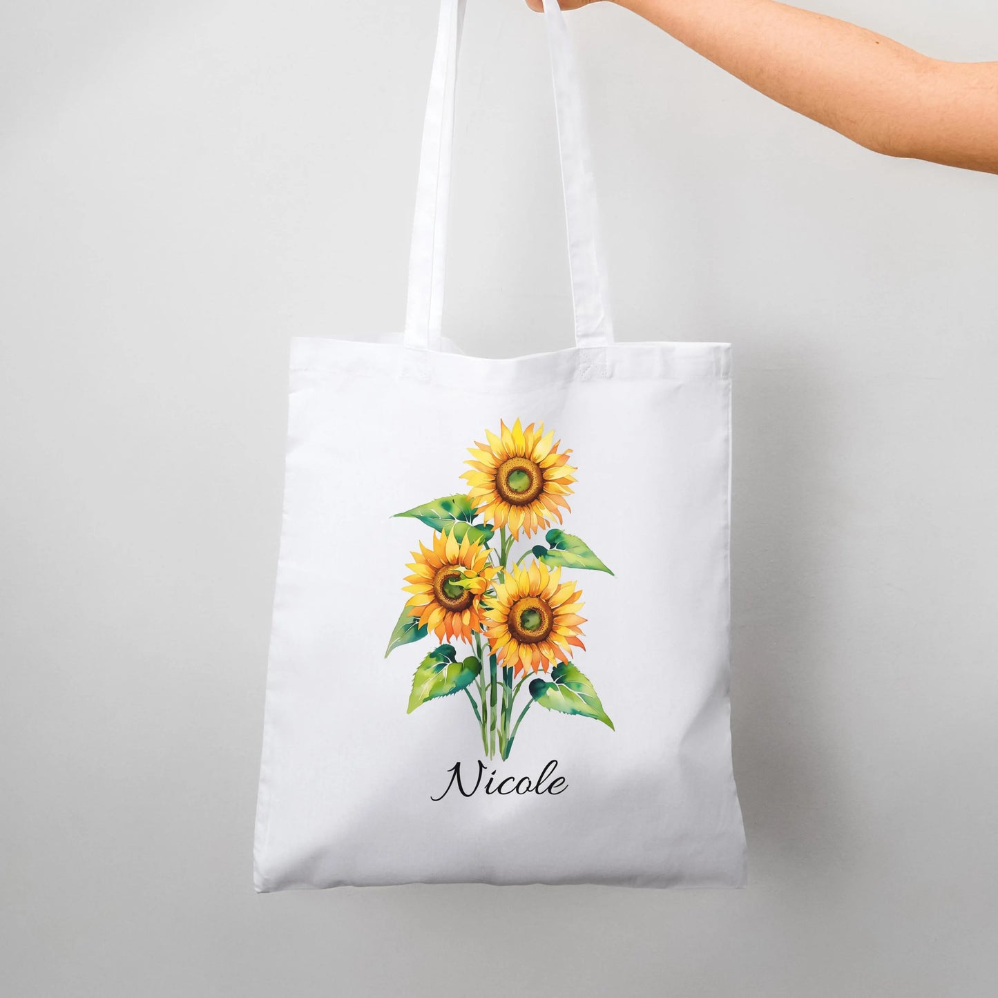 Sunflower Print Custom Name Floral Tote Bag personalized with Nicole hanging against a plain background