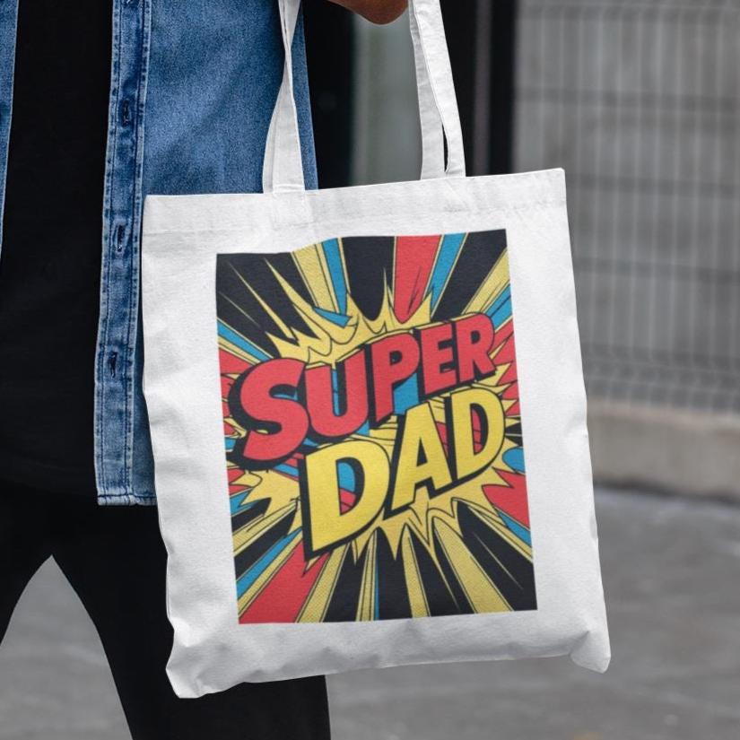 Tote bag with 'Super Dad' design held by a person wearing a denim jacket.