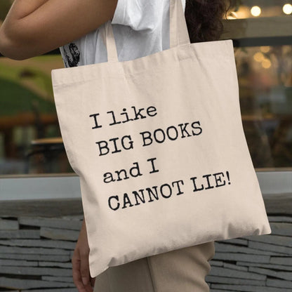 Woman carrying beige tote bag with bookish quote “I like BIG BOOKS and I CANNOT LIE!” – eco-friendly canvas reading bag