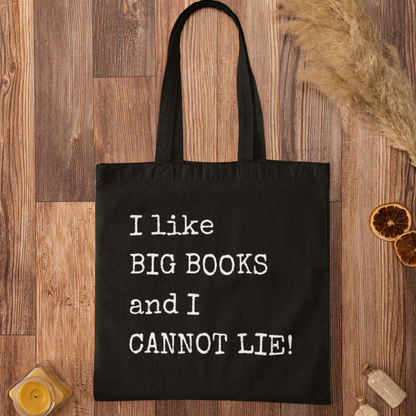 Black book lover tote bag with “I like BIG BOOKS and I CANNOT LIE!” printed in white, laid flat on rustic wood surface
