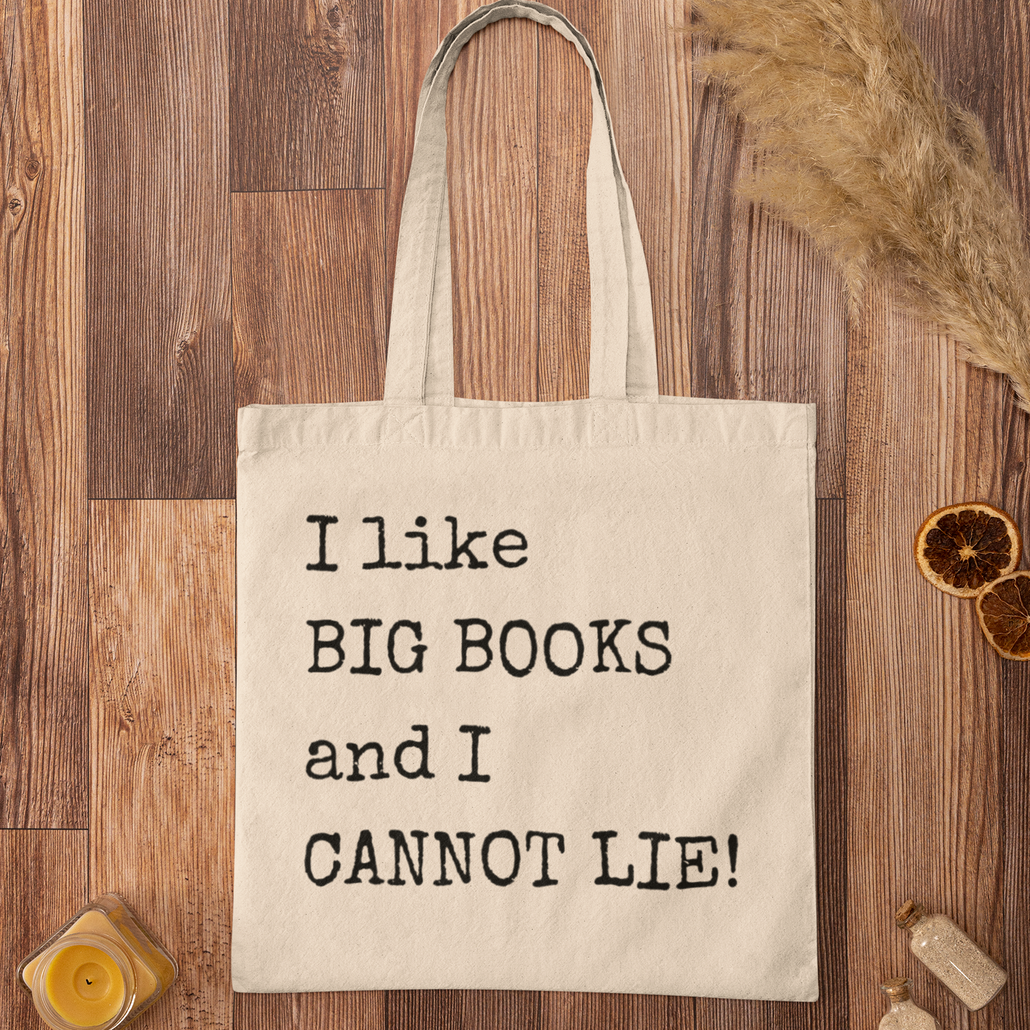 Natural canvas book tote bag with quote “I like BIG BOOKS and I CANNOT LIE!” styled on wooden background