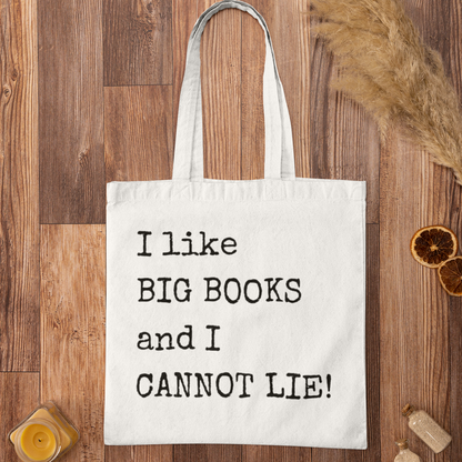 White minimalist tote bag with funny book quote “I like BIG BOOKS and I CANNOT LIE!” displayed on a wooden floor