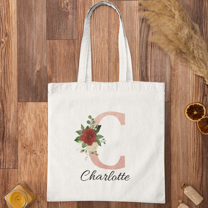Blush Pink and Roses Floral Custom Tote Bag with initial C and name Charlotte displayed on wooden background
