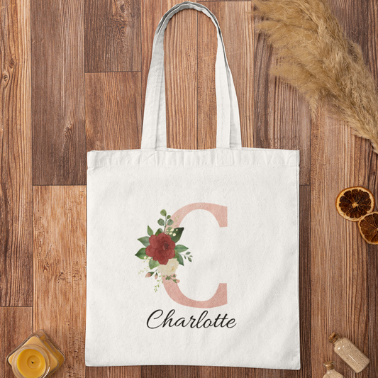 Blush Pink and Roses Floral Custom Tote Bag with initial C and name Charlotte displayed on wooden background