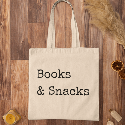 Books and Snacks quote printed on natural cotton canvas tote bag, flat lay