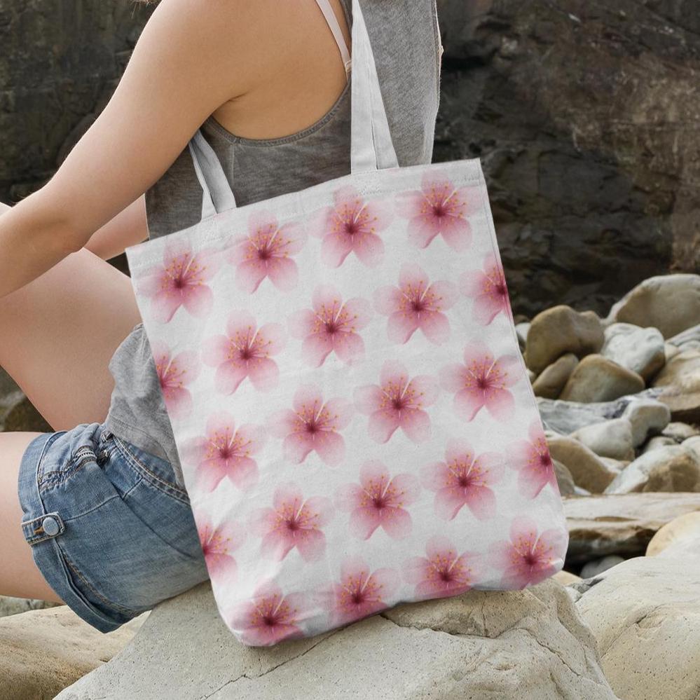 Cherry Blossom Sakura Pink Flower Pattern Tote Bag placed near rocks by the seaside