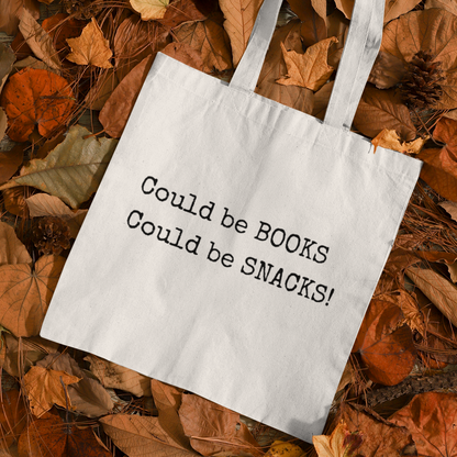 White Could Be Snacks Book Quotes Minimalist Tote Bag displayed on autumn leaves, aesthetic fall-themed eco tote for bookworms