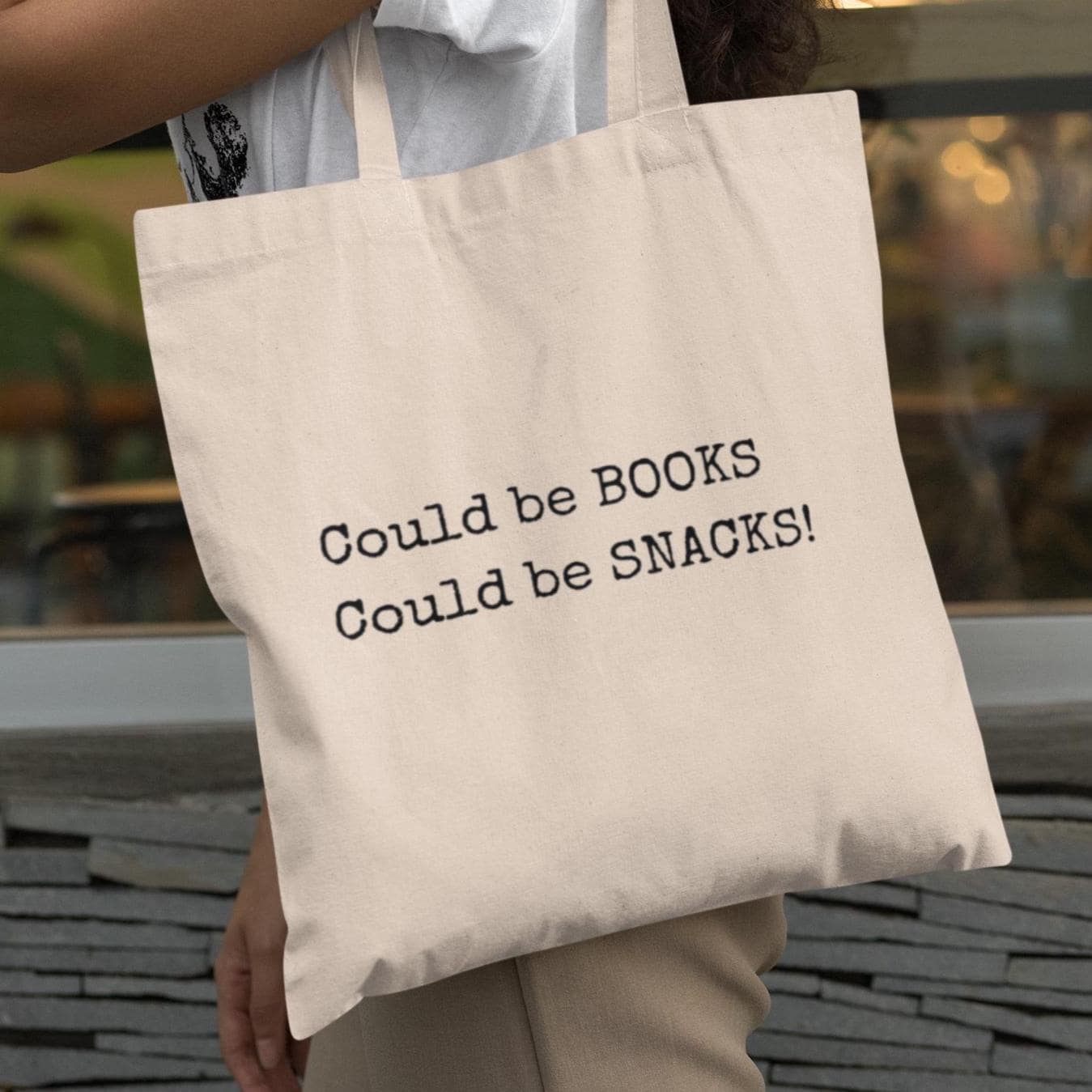 Natural canvas Could Be Snacks Book Quotes Minimalist Tote Bag carried by person, stylish everyday tote for book lovers and snack fans