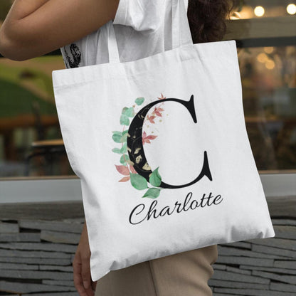 Model carrying Eucalyptus with Gold and Berry Leaf Custom Tote Bag personalized with the name Charlotte