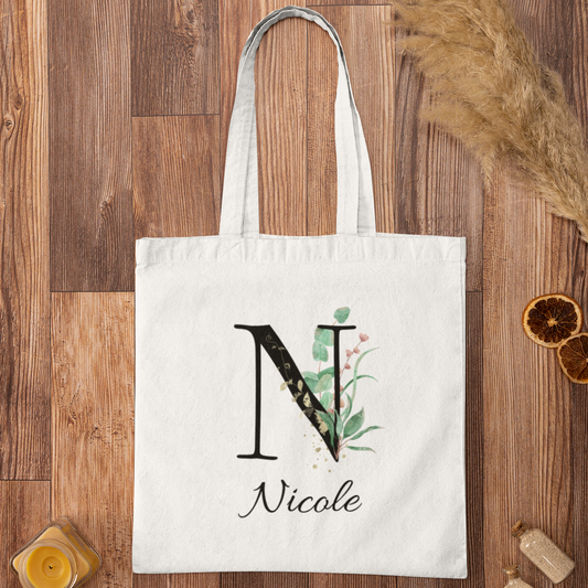 Flat lay of Eucalyptus with Gold and Berry Leaf Botanical Custom Tote Bag featuring elegant initial design and personalized name.