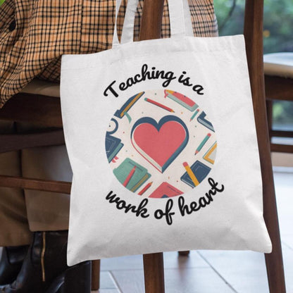 Heart Of A Teacher tote bag held on a chair – thoughtful teacher appreciation gift