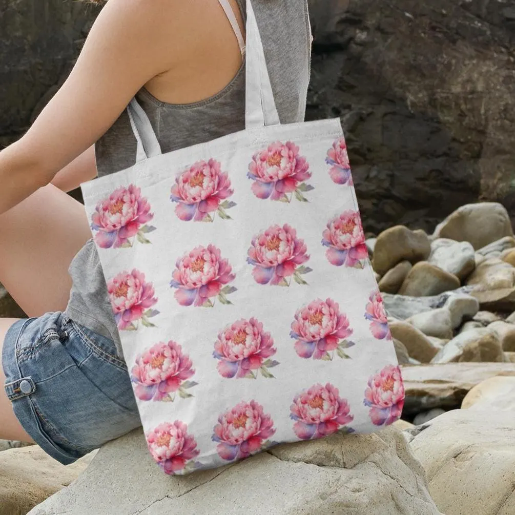 Pink Peony Bloom Pattern Floral Tote Bag resting on rocks by the beach, showing a feminine and summery look