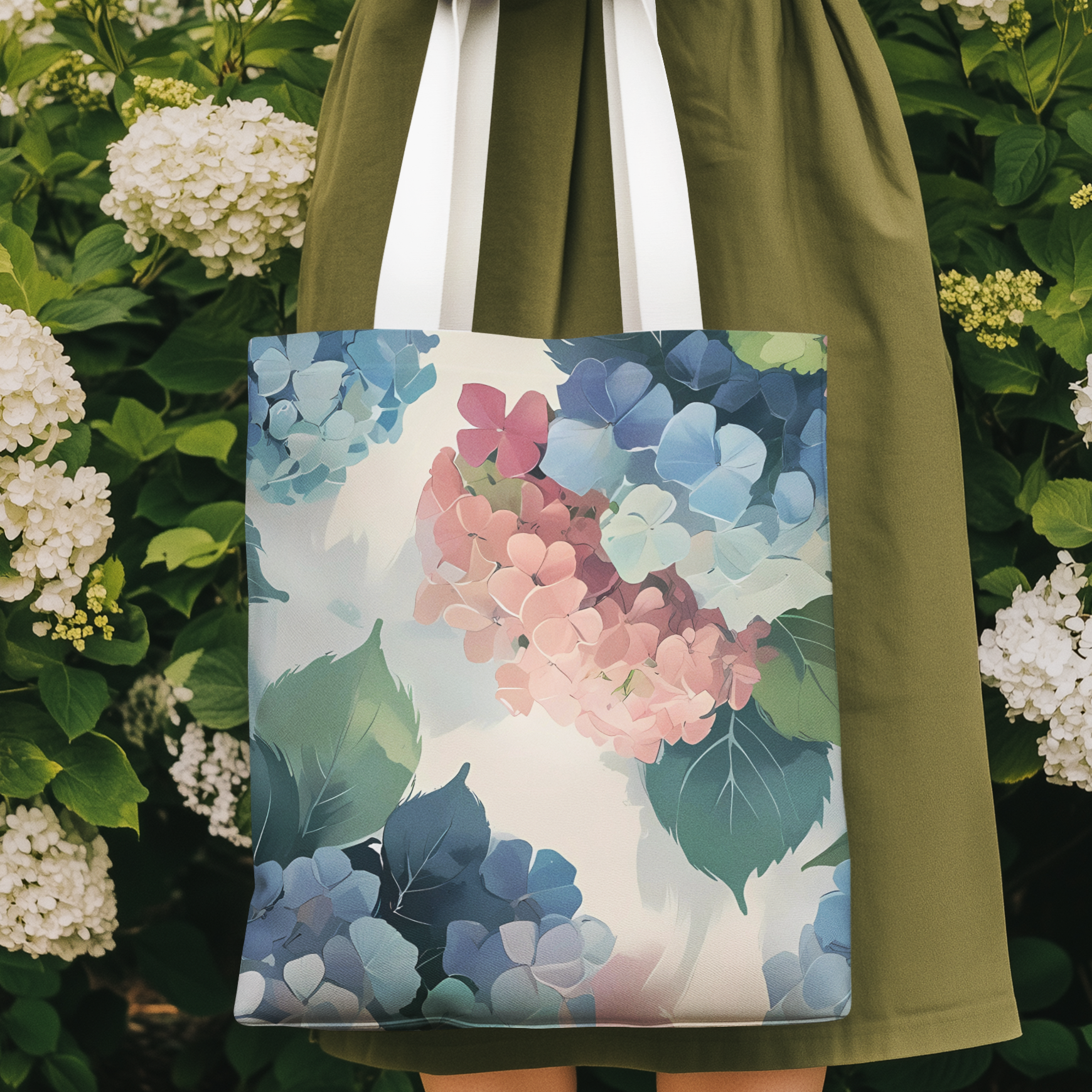 Woman holding hydrangea pastel floral tote bag in blooming garden, featuring elegant abstract flower art.