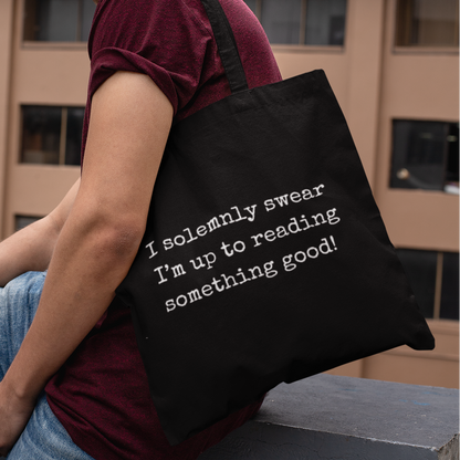 Model carrying black I Solemnly Swear Reading Quote Minimalist Book Bag, stylish reading-themed tote for everyday use