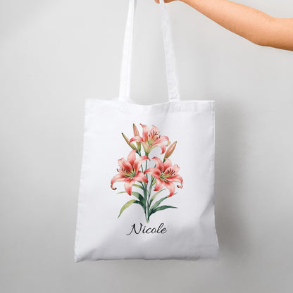 White tote bag with pink tiger lilies and 'Nicole' text on a light gray background