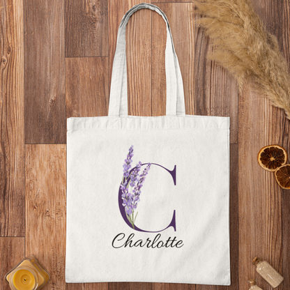 Lavender Floral Custom Tote Bag With Purple Initial “C” for Charlotte displayed on wooden background