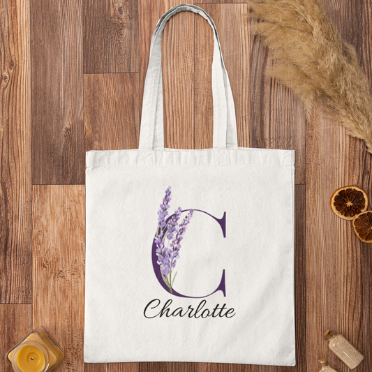 Lavender Floral Custom Tote Bag With Purple Initial “C” for Charlotte displayed on wooden background
