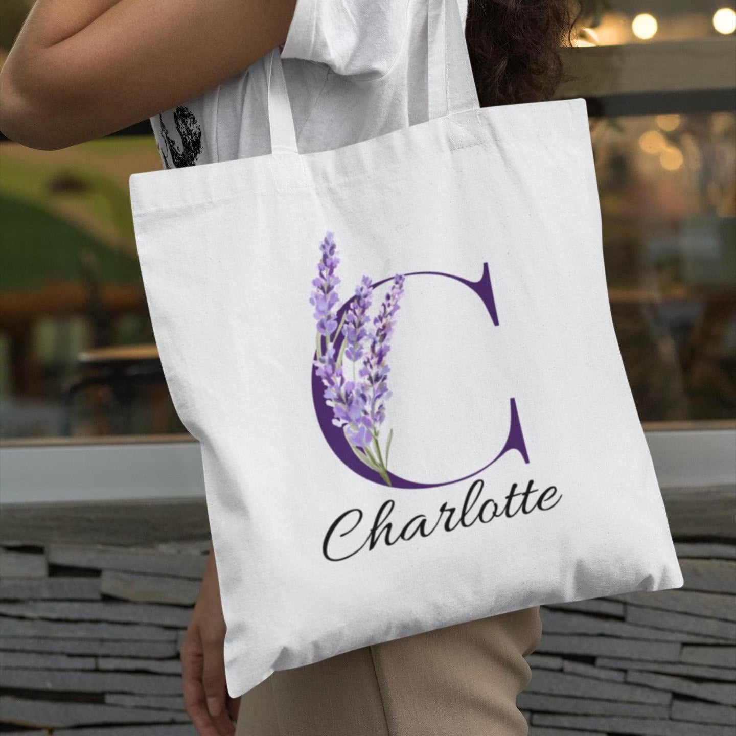 Woman carrying a Lavender Floral Custom Tote Bag With Purple Initial “C” outdoors