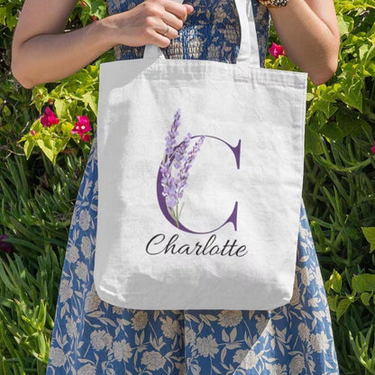 Close-up of Lavender Floral Custom Tote Bag With Purple Initial “C” for Charlotte held outdoors among greenery