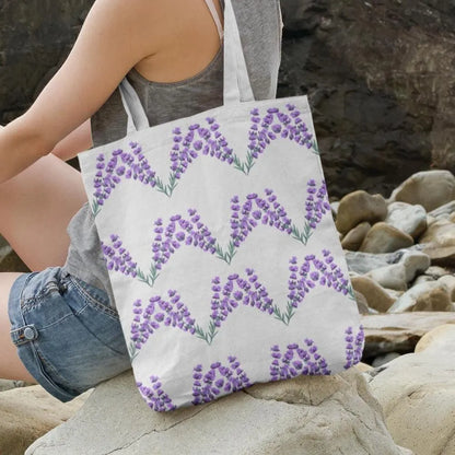 Lavender flower design tote bag resting on rocks, eco-friendly canvas bag with purple lavender print