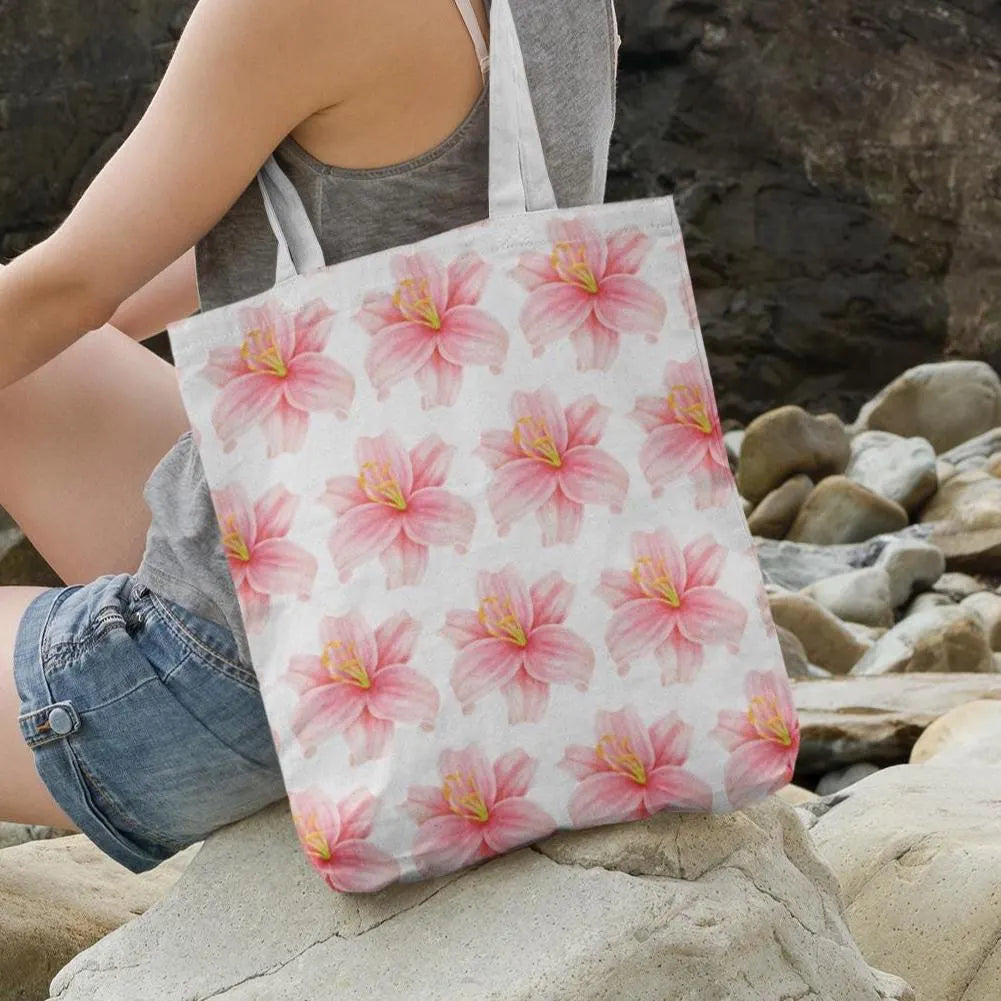 Woman sitting on rocks carrying Lily Flower Design Patterned Tote Bag showcasing pastel pink lilies