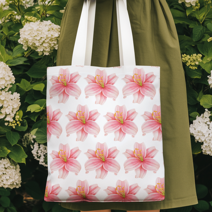 Lily Flower Design Patterned Tote Bag hanging against green foliage with delicate pink flower pattern