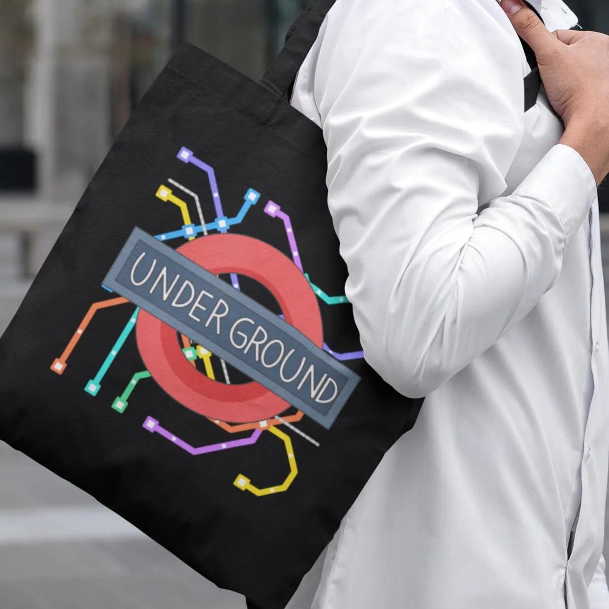 Man carrying black tote bag with colourful London Underground map print – modern travel tote for commuters