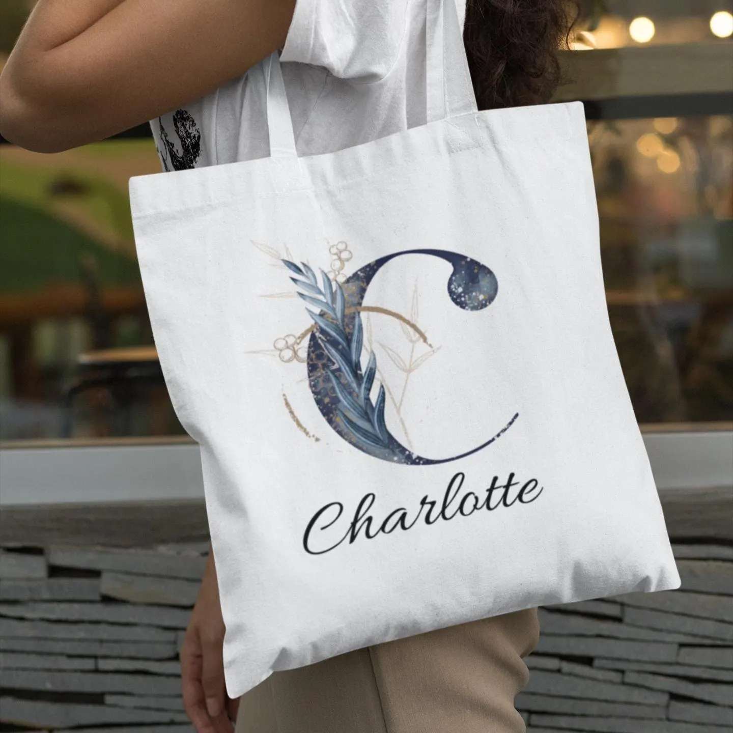 Woman carrying navy blue and gold initial tote bag with letter C and name Charlotte, personalized gift idea
