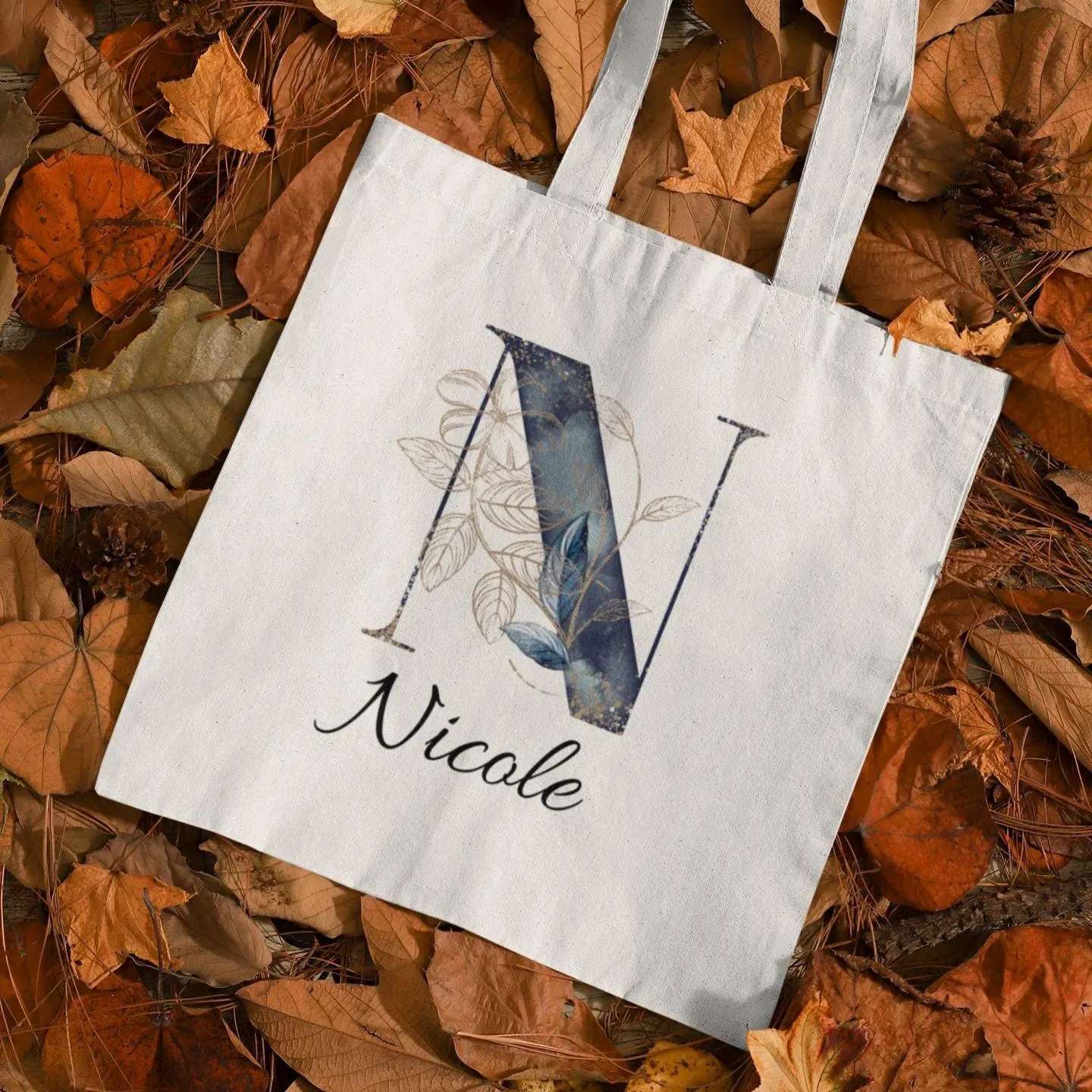 Personalized navy and gold tote bag with letter N and name Nicole, elegant midnight botanical design in autumn leaves