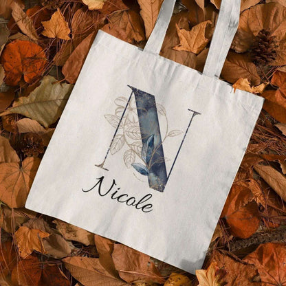 Personalized navy and gold tote bag with letter N and name Nicole, elegant midnight botanical design in autumn leaves