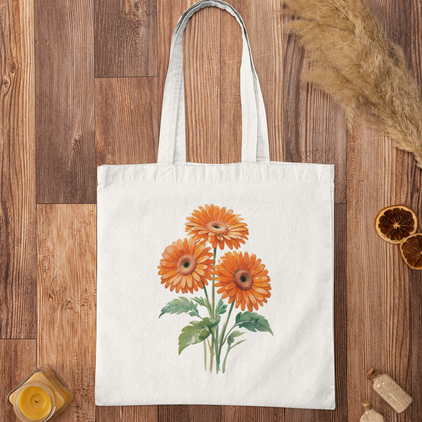 White tote bag with orange gerbera floral illustration placed flat on wooden background for display