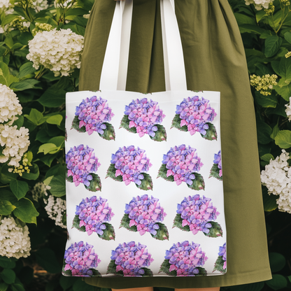 Woman holding Hydrangea Patterned Floral Design Tote Bag with pink hydrangea print among blooming flowers