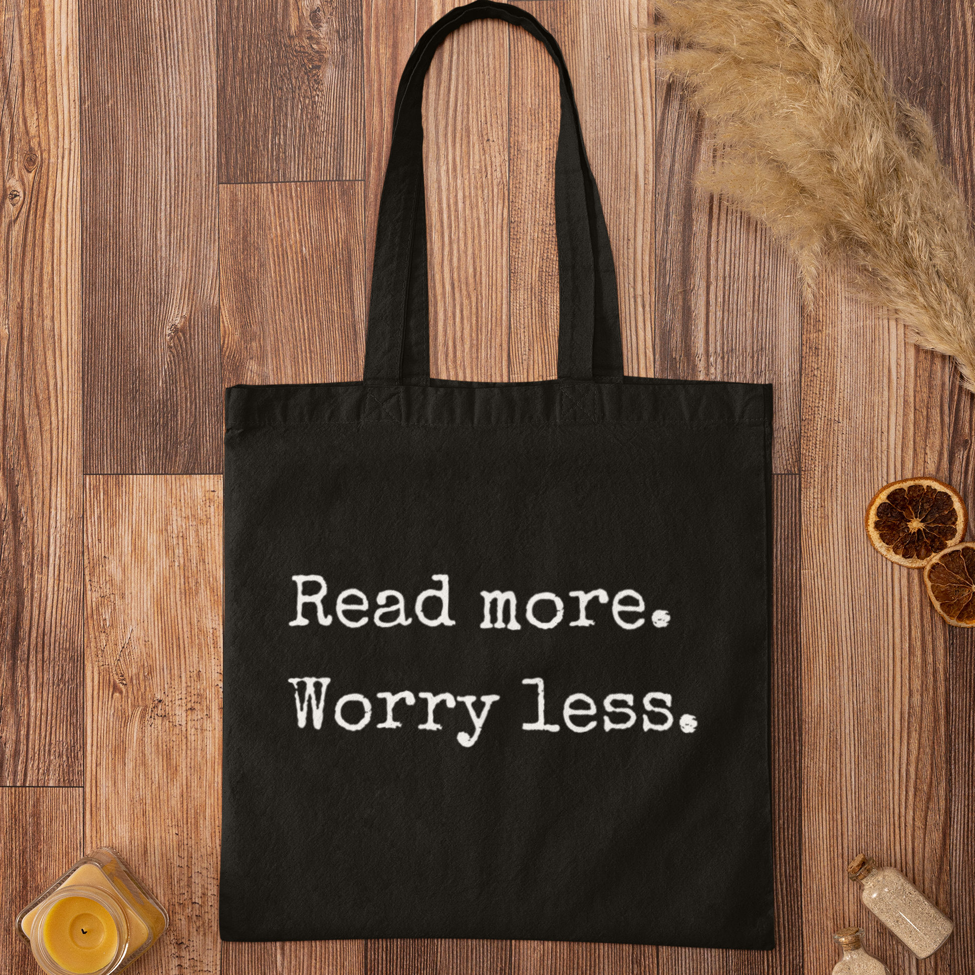 Black cotton tote bag with ‘Read more. Worry less.’ minimalist typography – perfect for book lovers