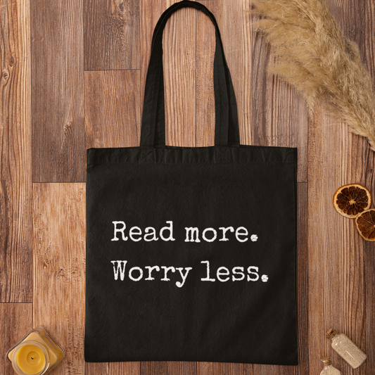 Black cotton tote bag with ‘Read more. Worry less.’ minimalist typography – perfect for book lovers