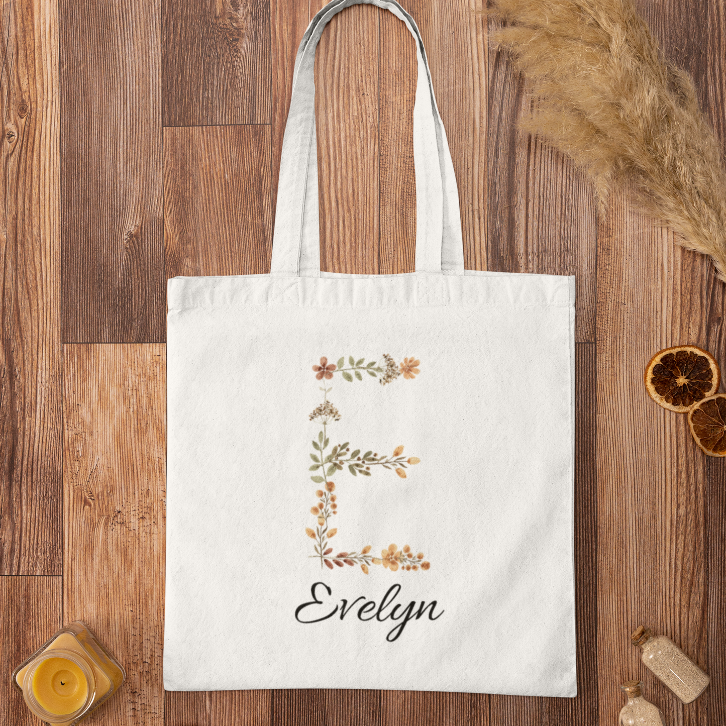 Rustic floral tote bag with letter E and name Evelyn on wooden surface, custom name canvas bag