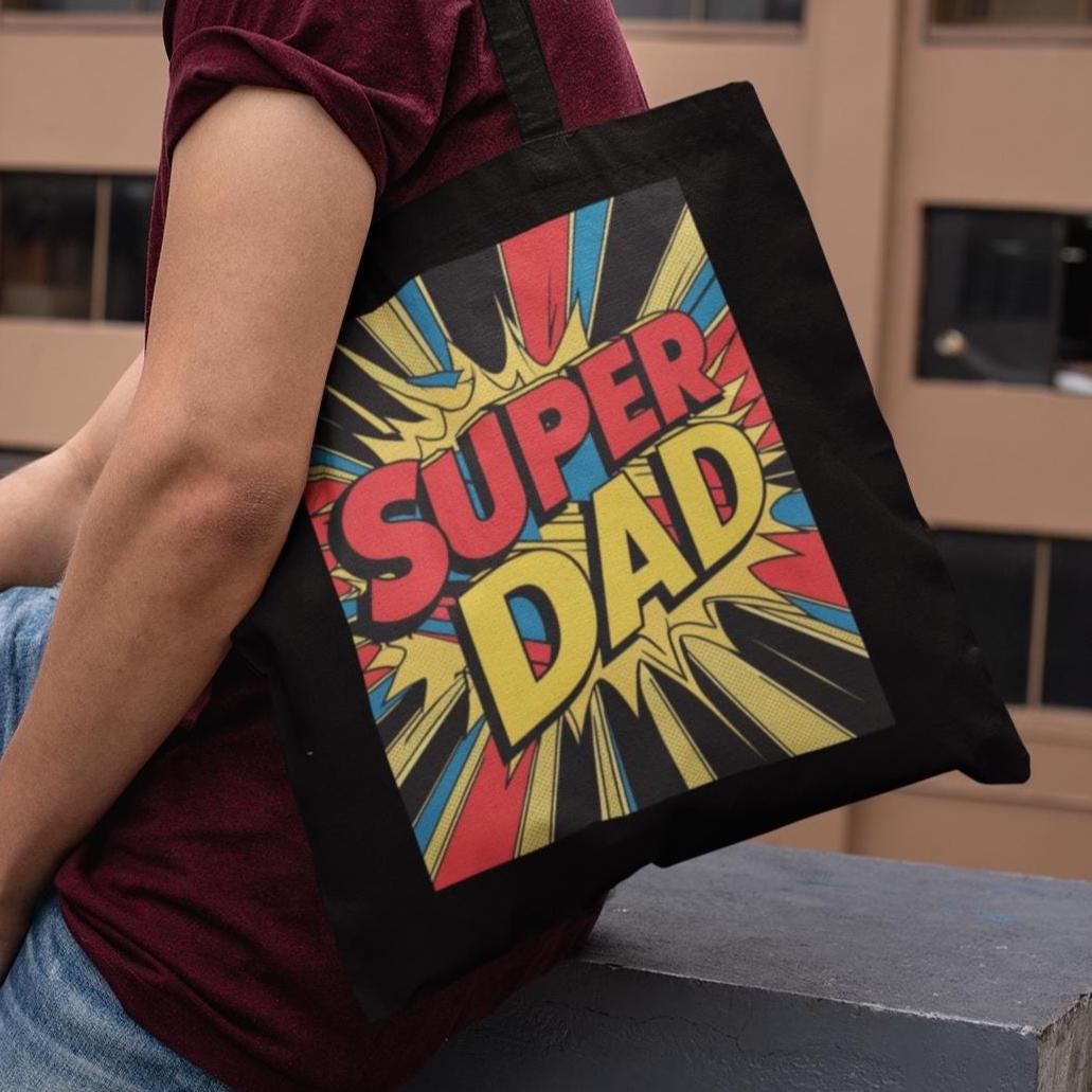 Model sitting while carrying black Super Dad Retro Gift Tote Bag with retro comic design