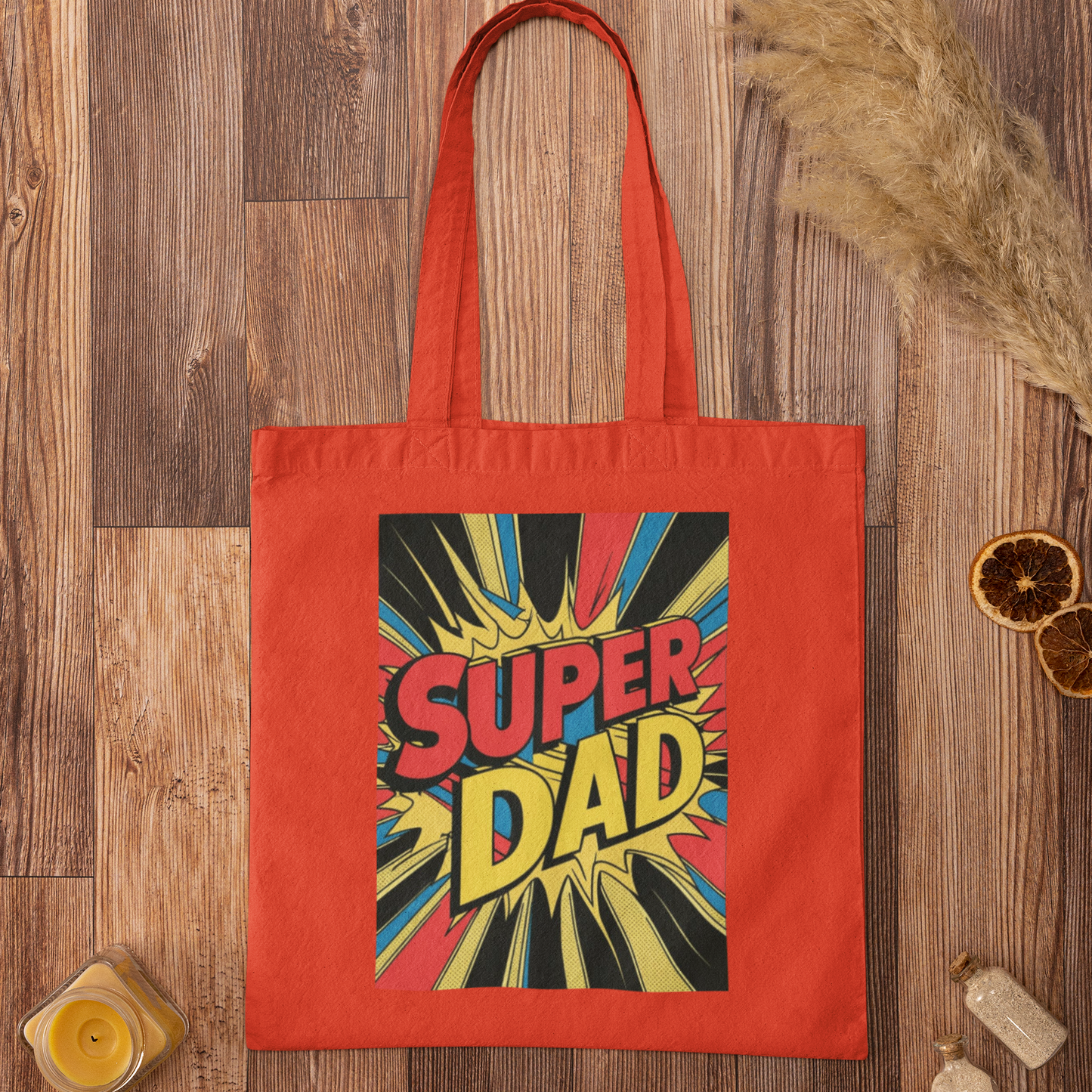 Red tote bag with 'Super Dad' design on a wooden surface