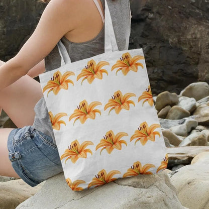 Woman sitting on rocks carrying Tiger Lily Flower Design Tote Bag with orange floral pattern