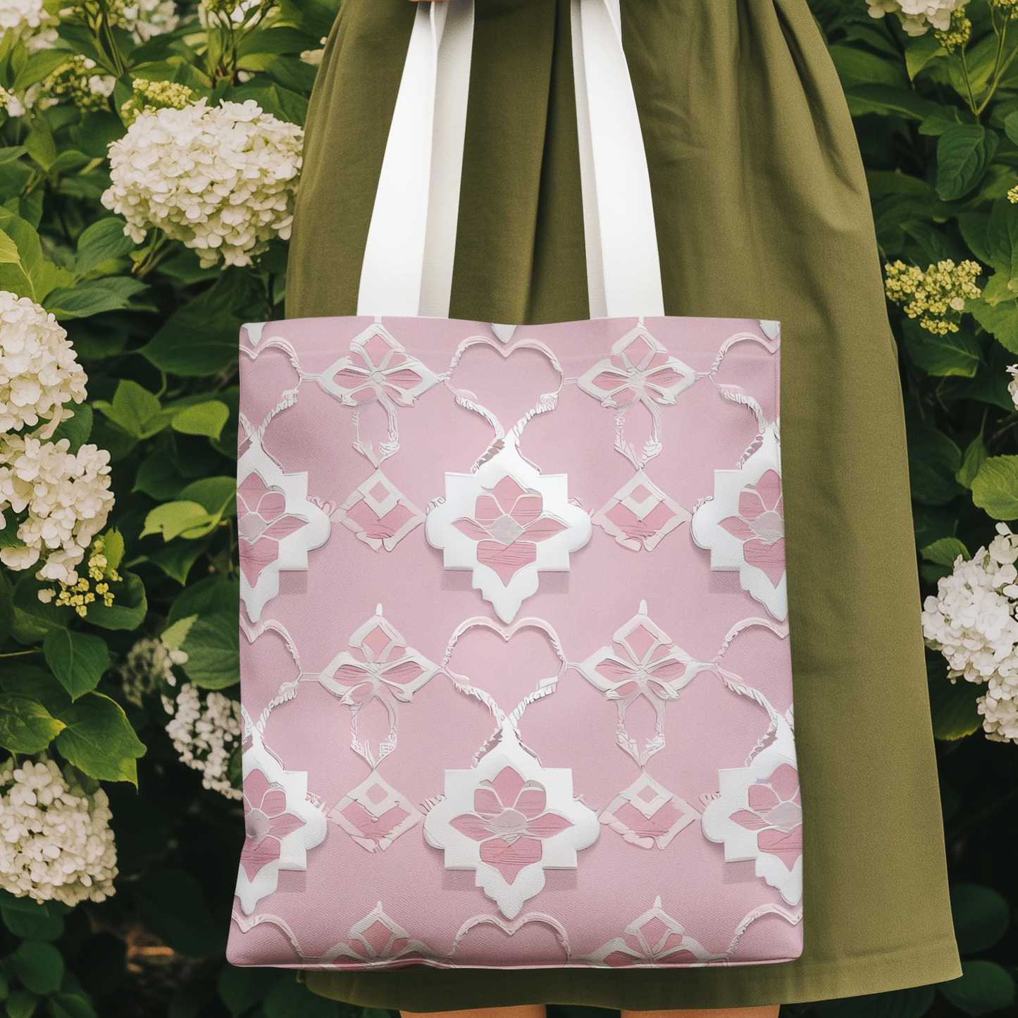 Model holding baby pink Moroccan print tote bag in garden surrounded by white hydrangeas